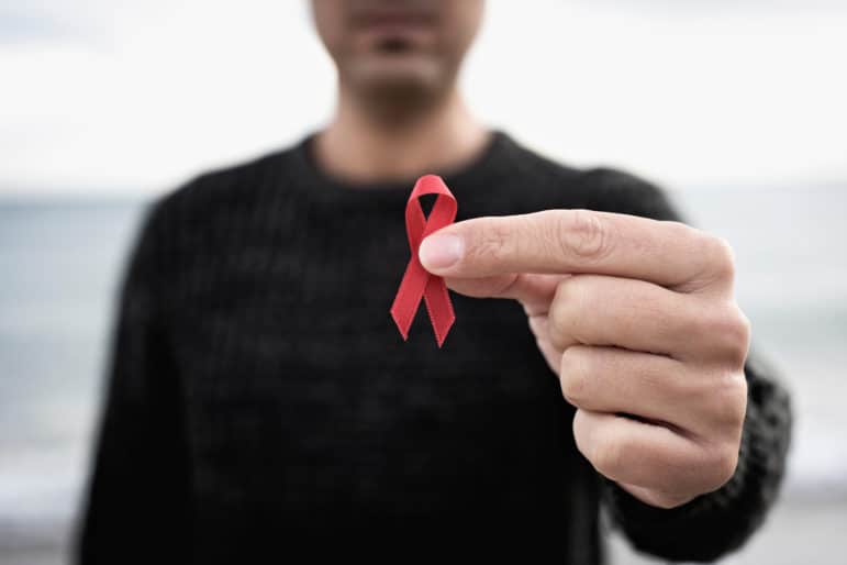 closeup,of,a,young,man,with,a,red,awareness,ribbon